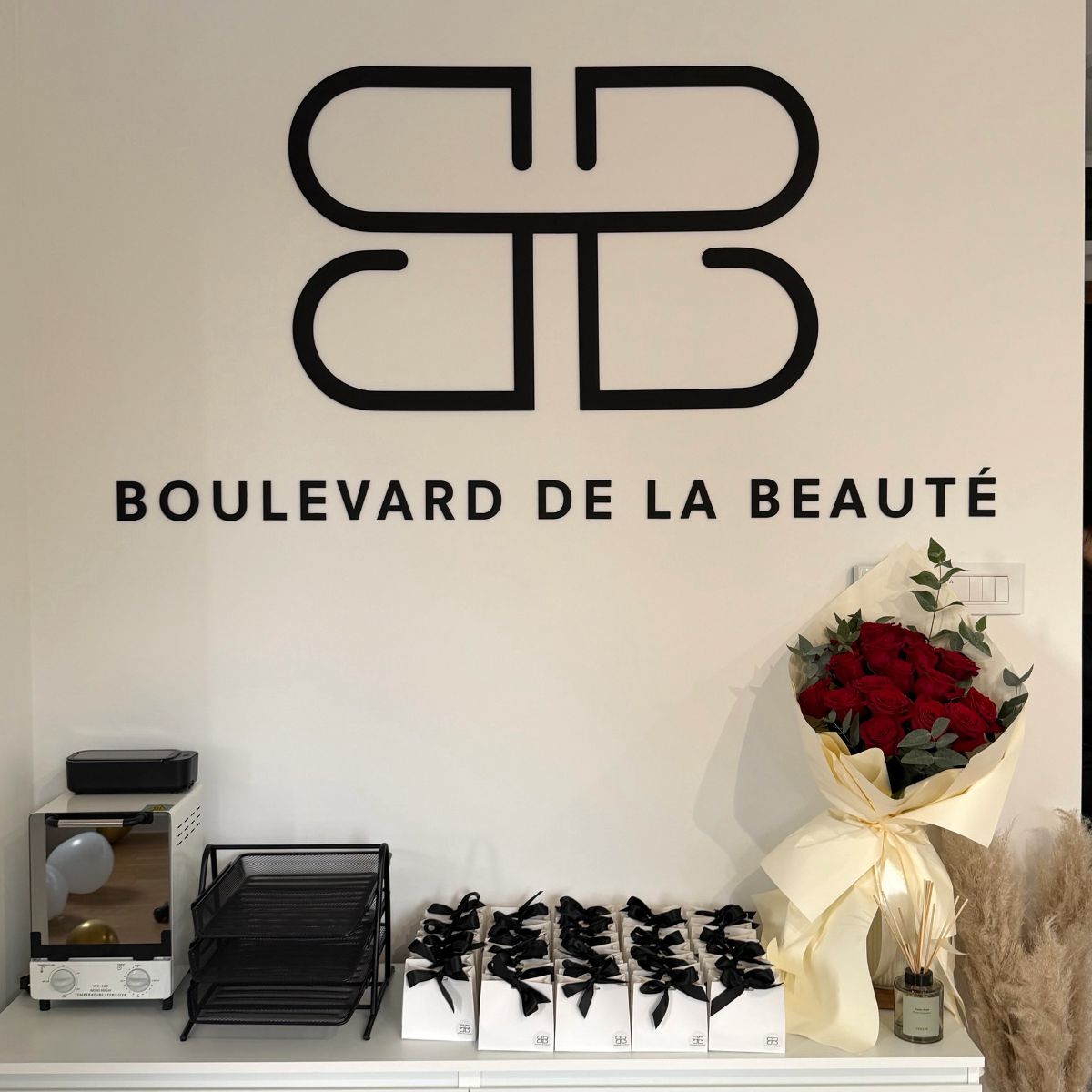 Logotip Boulevard de la Beauté od crnog pleksiglasa na zidu salona